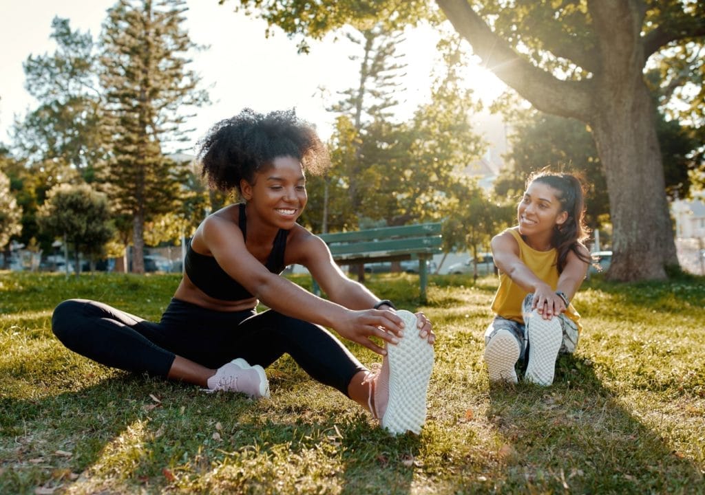 a group of women stretching in the grass