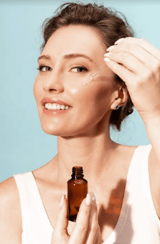 a woman applying a dropper on her face